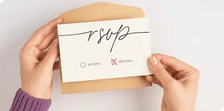 Hands holding declined RSVP card